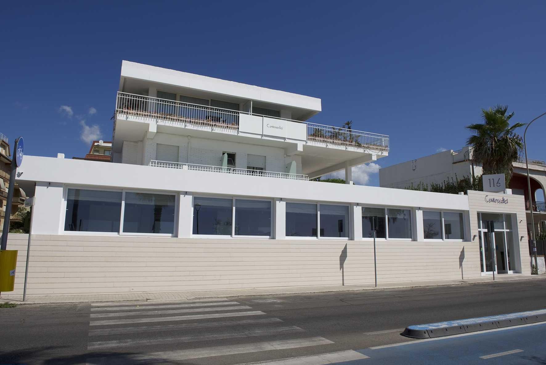 Facciata bianca dell'hotel-ristorante sul lungomare, palma, insegna «116 Centosedici» sull'edificio, Centosedici