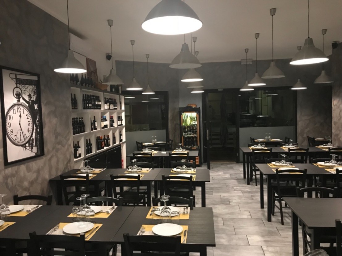 La sala con i tavoli scuri apparecchiati, La Drogheria Restaurant