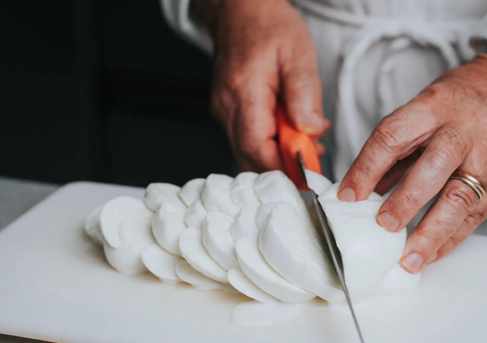 Lo chef Nazareno Fontana taglia a fette una treccia di mozzarella di bufala al Bufala Day del Ristorante Il Caminetto