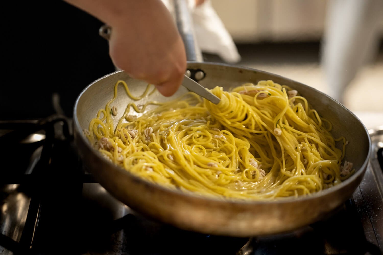 Una mano manteca spaghetti in padella sul fuoco, Ristorante Grappolo D’Uva Ricevimenti